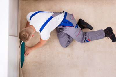 High Angle View Of A Craftsman Installing Carpet On Floor